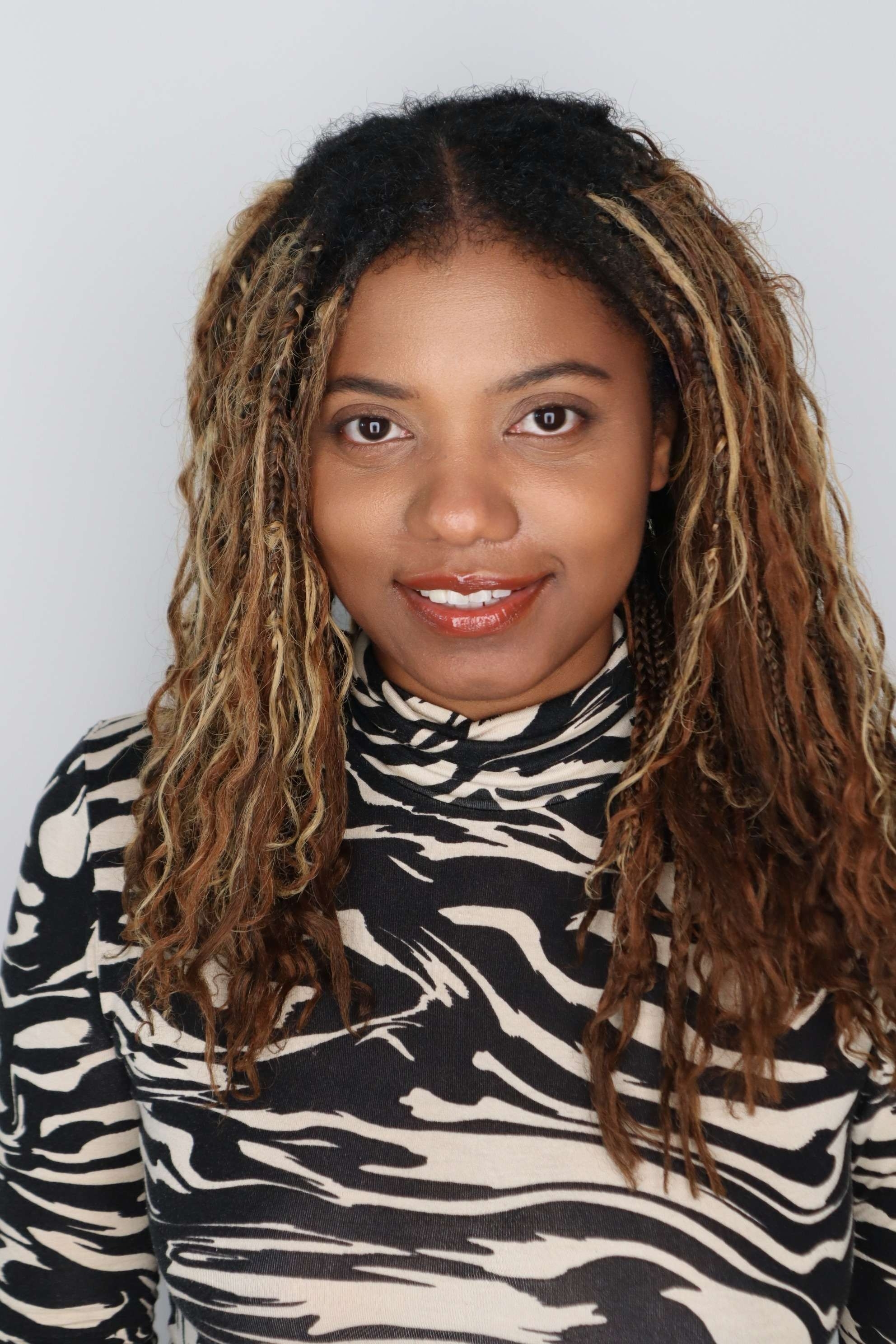 Sonita Moss headshot smiling gray background black and white pattern top